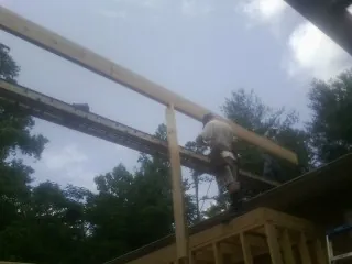 Carpenter setting a ridge beam over a new addition frame — Ice Dam Removal by Roofing Brothers in Ansted