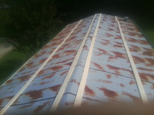Rusted metal roof panels with new wood purlins before replacement — Storm Damage Roof Repair in Ansted by Roofing Brothers