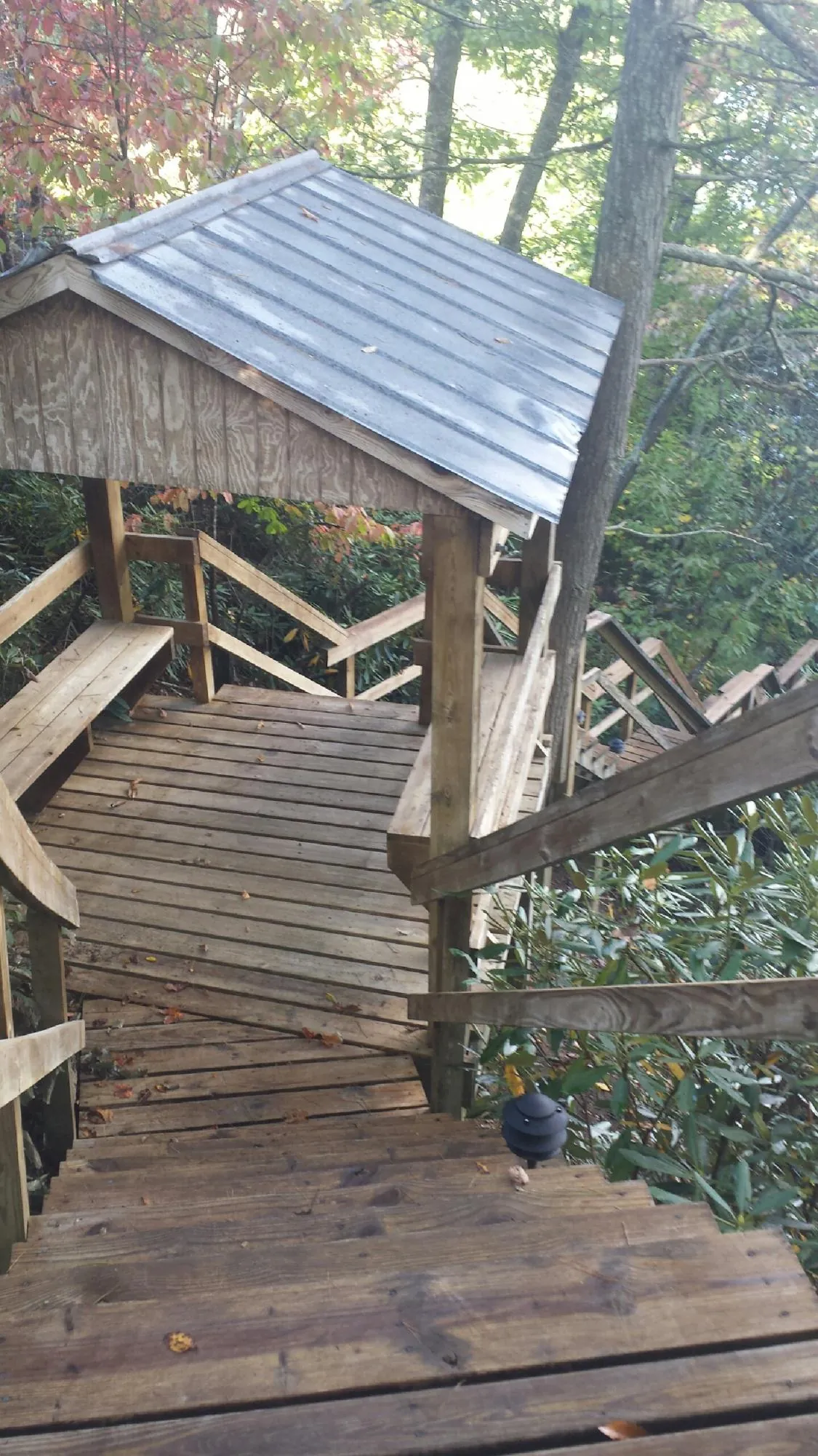 Metal roofed shelter over wooden steps on a wooded walkway — Skylight Repair & Installation work by our crew in Ansted