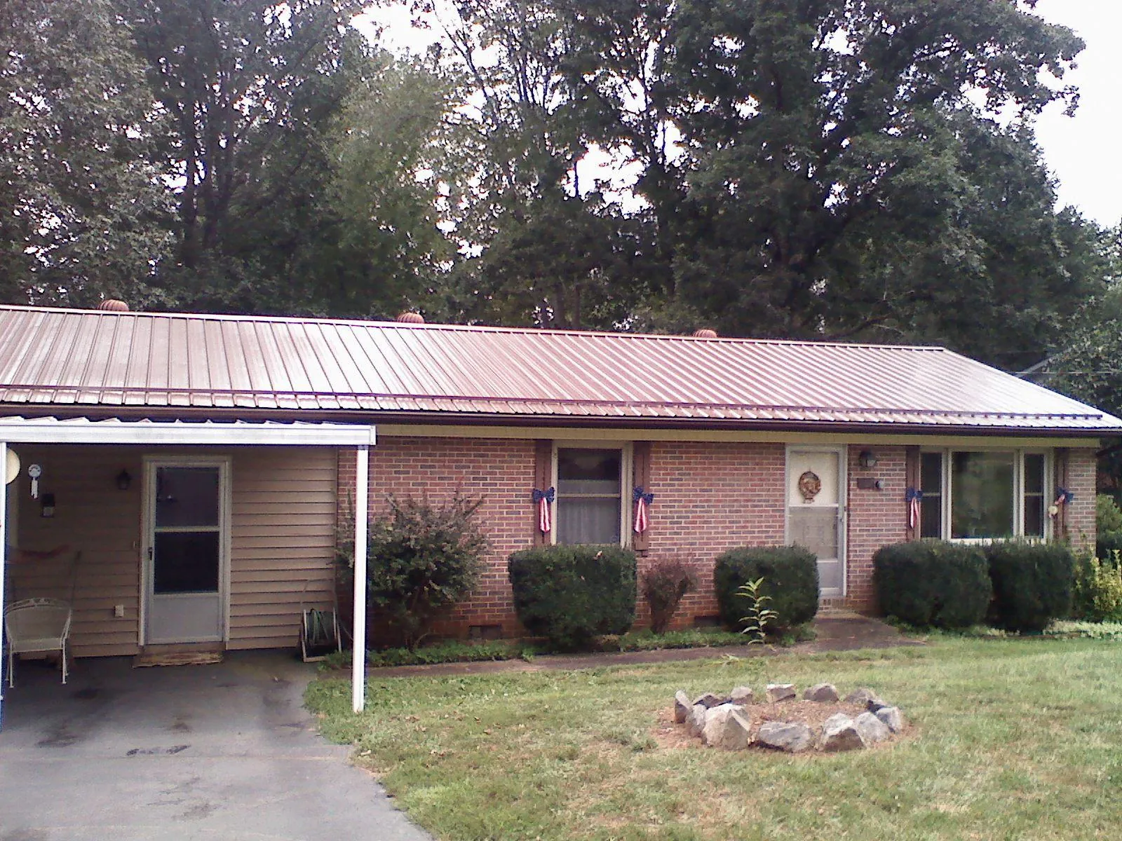 Bronze metal roof and carport on a brick ranch home — Roof Repair work by our crew in Ansted